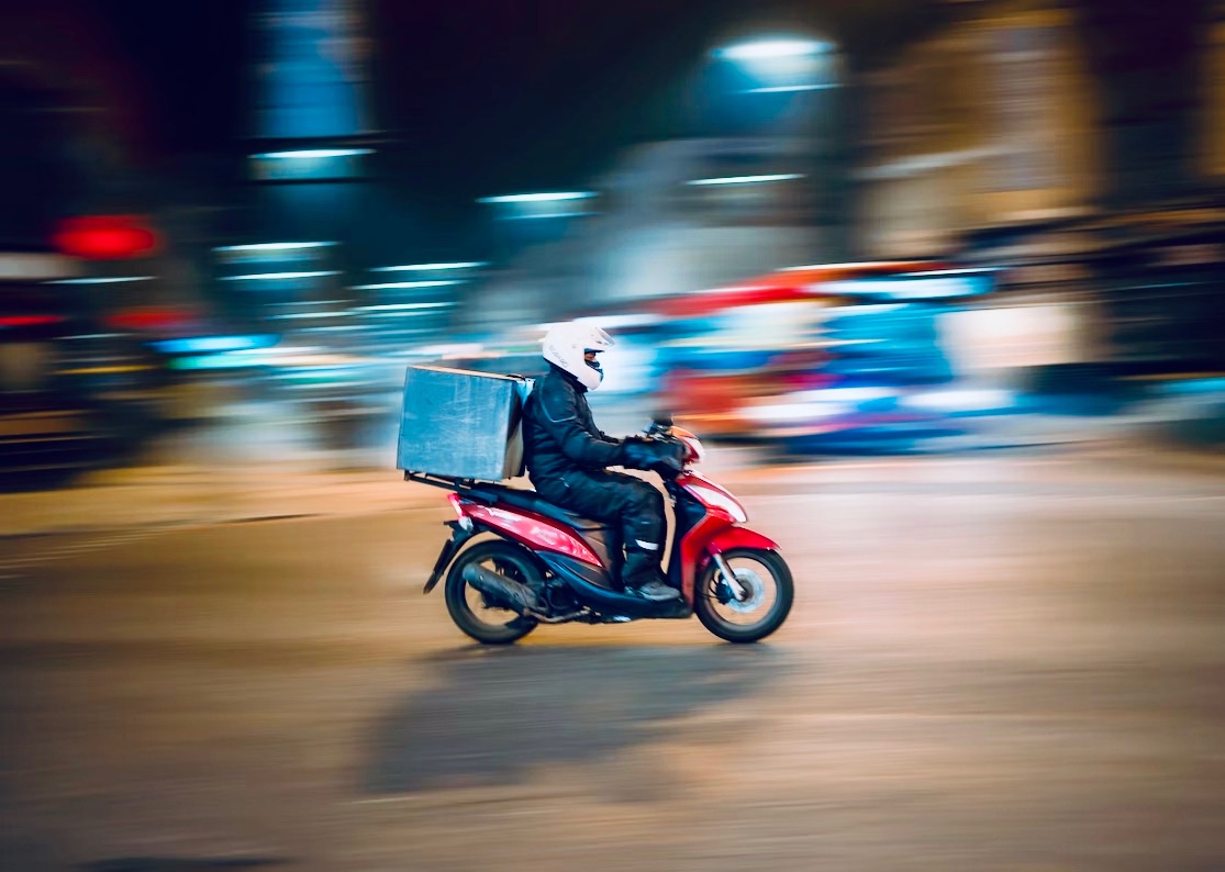 Motorcycle being ridden at night in the city.
